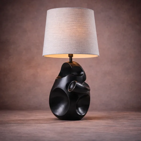Front view of modern table lamp with an asymmetrical carved black base