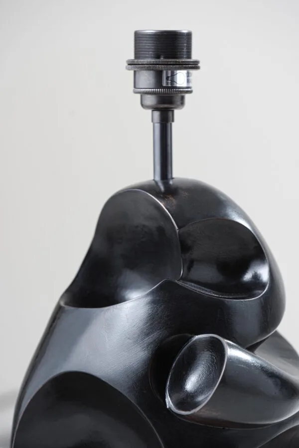 Side angle of modern table lamp showing the carved charcoal-bronze sculptural body