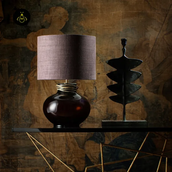 Amber borosilicate glass lamp styled on a console table in a warm, art-filled interior
