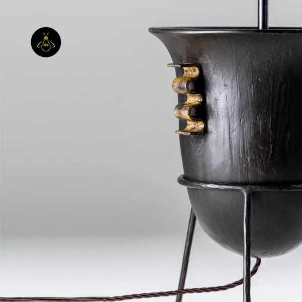 Close-up of the distressed-wood amphora body and antique-gold scroll accents on the Etrusco table lamp