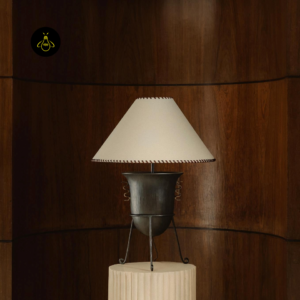Living room table lamp styled against a wood panel backdrop