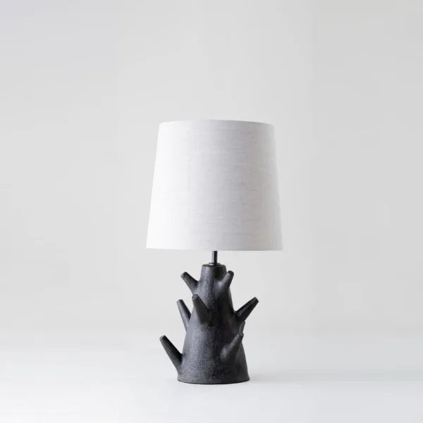 Rustic table lamp with charcoal branch base and warm linen drum shade for a bedside table