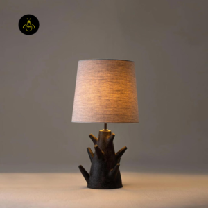 Rustic table lamp lit with warm glow and tapered fabric shade