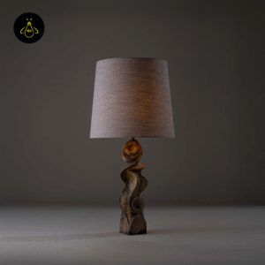 Dorian table lamp lit view showing warm ambient glow and sculptural burnt wood base