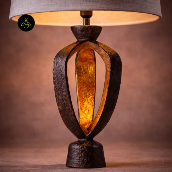 Close-up of small table lamp base showing the glowing gold inner surface and copper texture