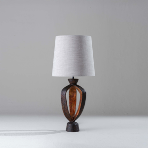 Small designer lamp with open sculptural body and linen shade