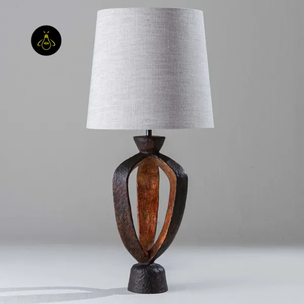 Front view of small bedroom table lamp with an open copper-and-gold sculptural base