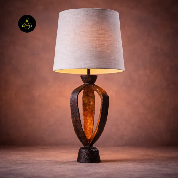 Side angle of compact bedside table lamp with fired-copper finish and linen drum shade