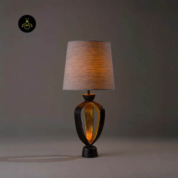 Small bedroom table lamp glowing on a bedside surface with warm ambient light