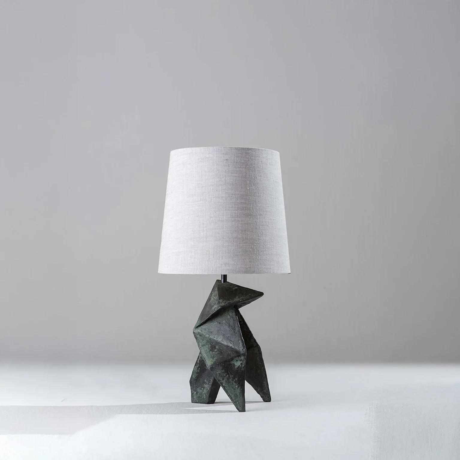 Modern table lamp with sculptural wooden base and linen shade