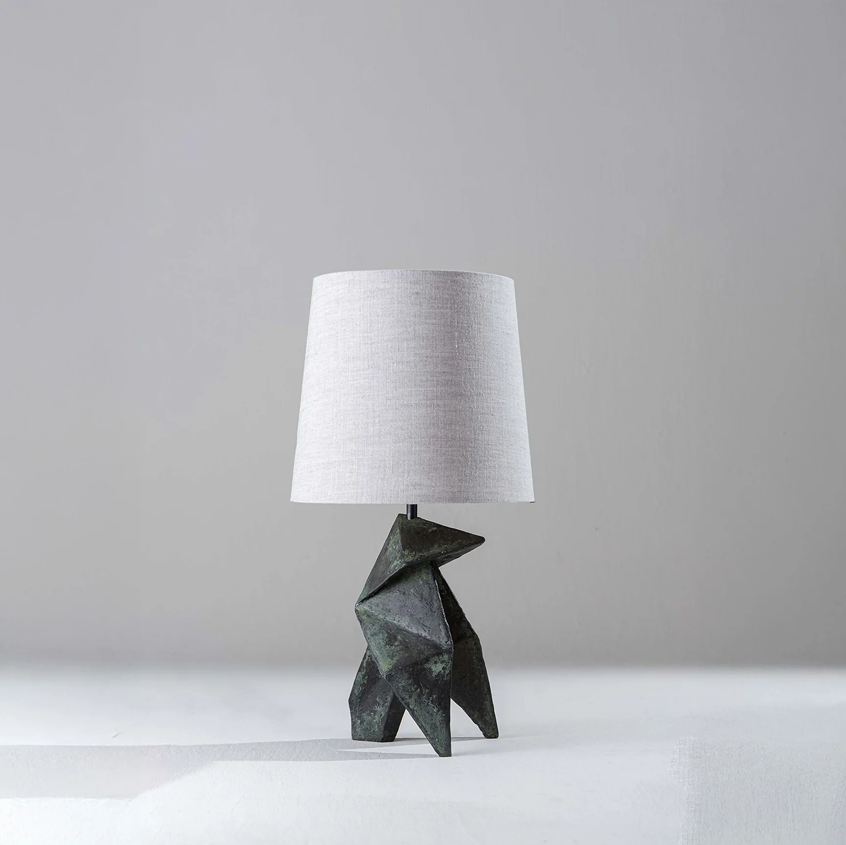Modern table lamp with sculptural wooden base and linen shade