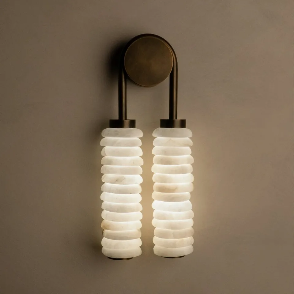 Stacked alabaster wall light with twin white alabaster drops on an aged-brass frame for a bedroom