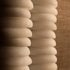 Designer wall light side angle view showing the depth and suspended alabaster form