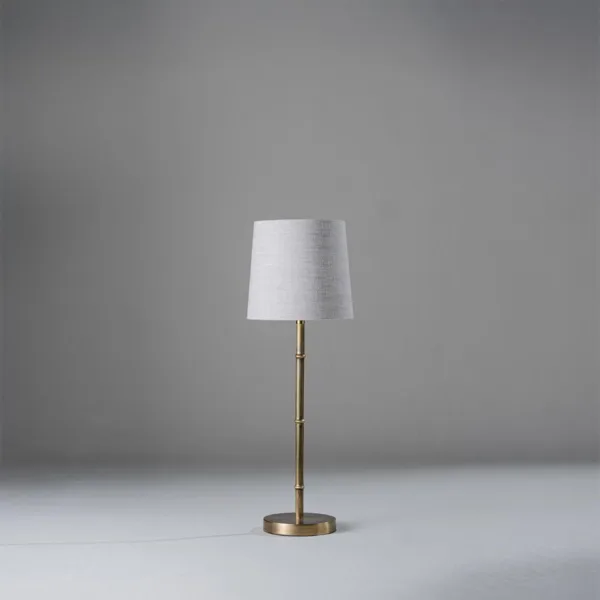 Mini brass table lamp with a slim bamboo-node stem and grey-linen shade for a narrow nightstand