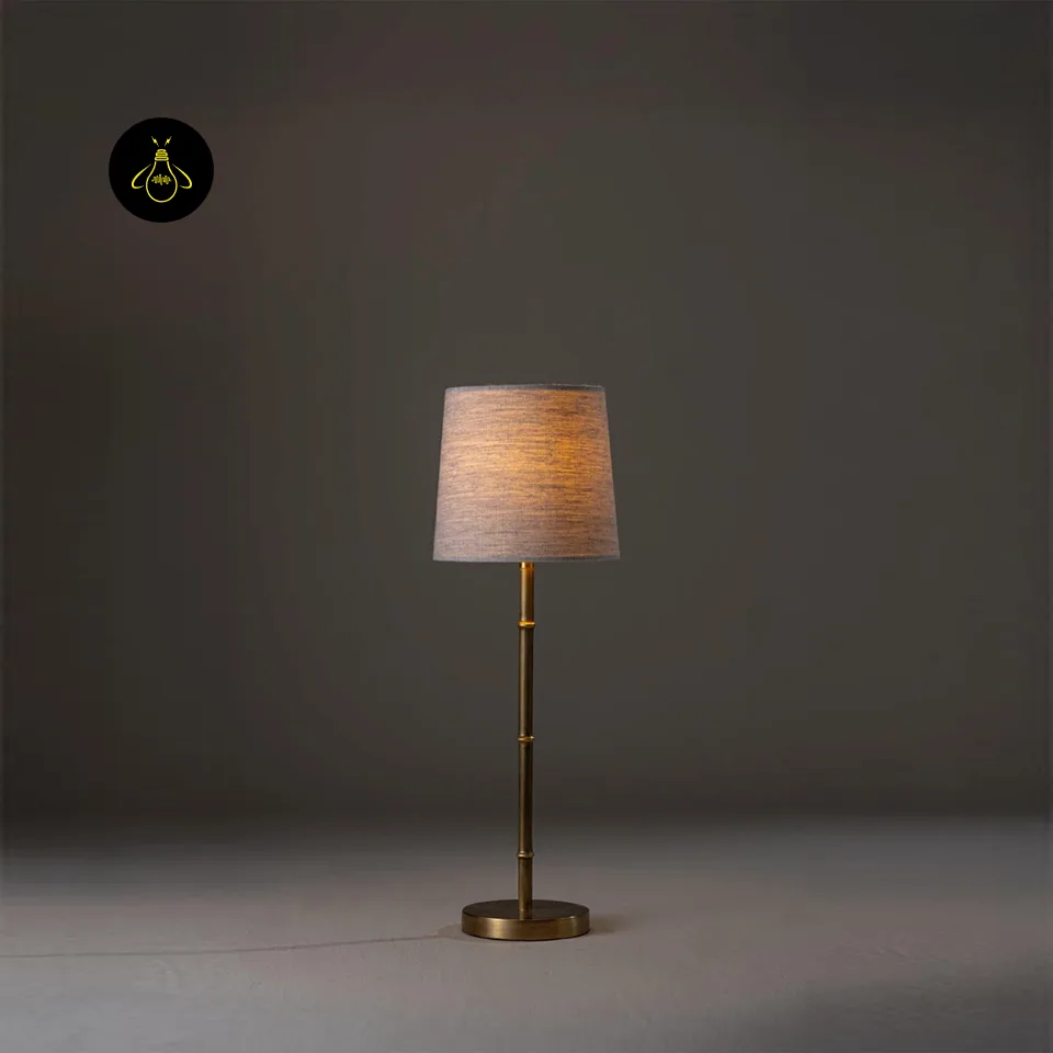 Mini Brass Table Lamp – Slim Bamboo-Stem Design, 53 cm 2 Mini brass table lamp lit to show a warm bedside glow through the linen shade