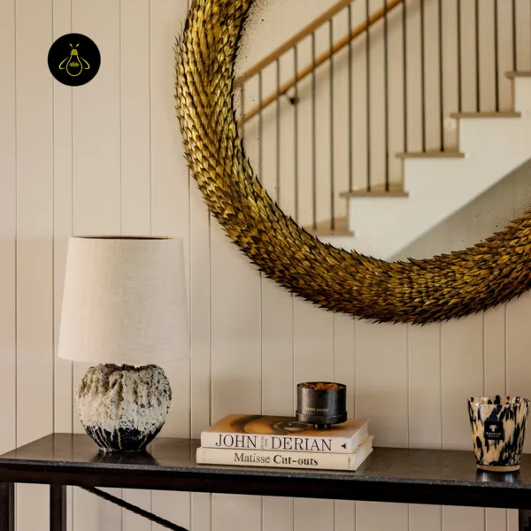Wabi sabi table lamp styled beneath a round mirror on a console table