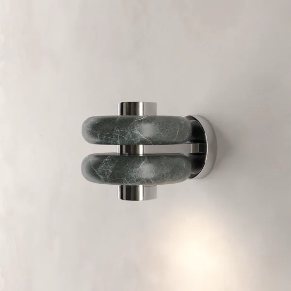 Green marble wall light with two veined marble bands and polished stainless steel cylinders, casting a warm beam down a pale wall