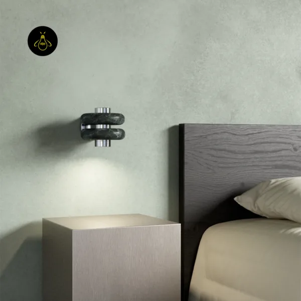 Green marble wall light beside a bed, lighting a bedside table with a soft downward beam