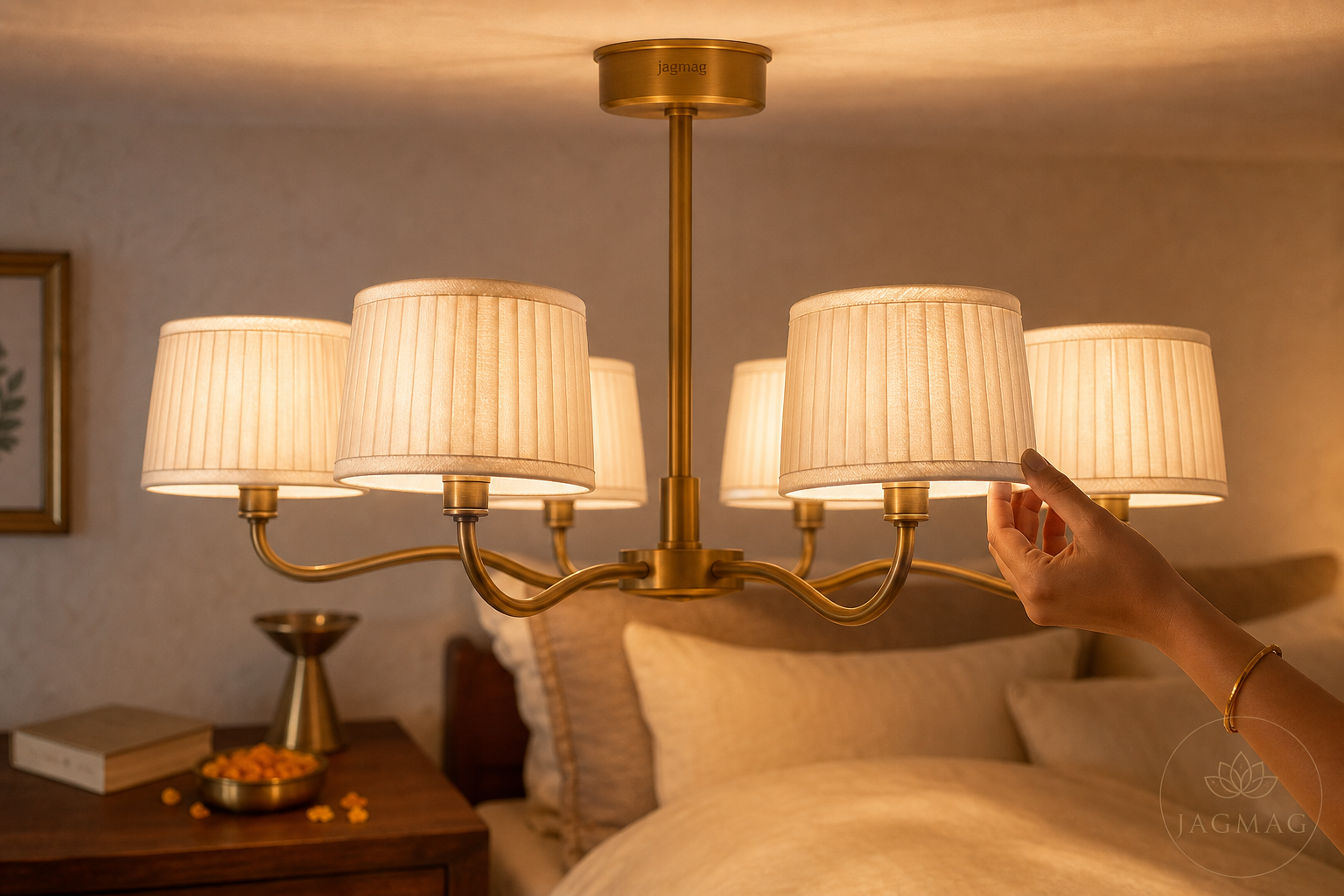 Fabric chandelier with pleated white shades glowing warm in an Indian bedroom