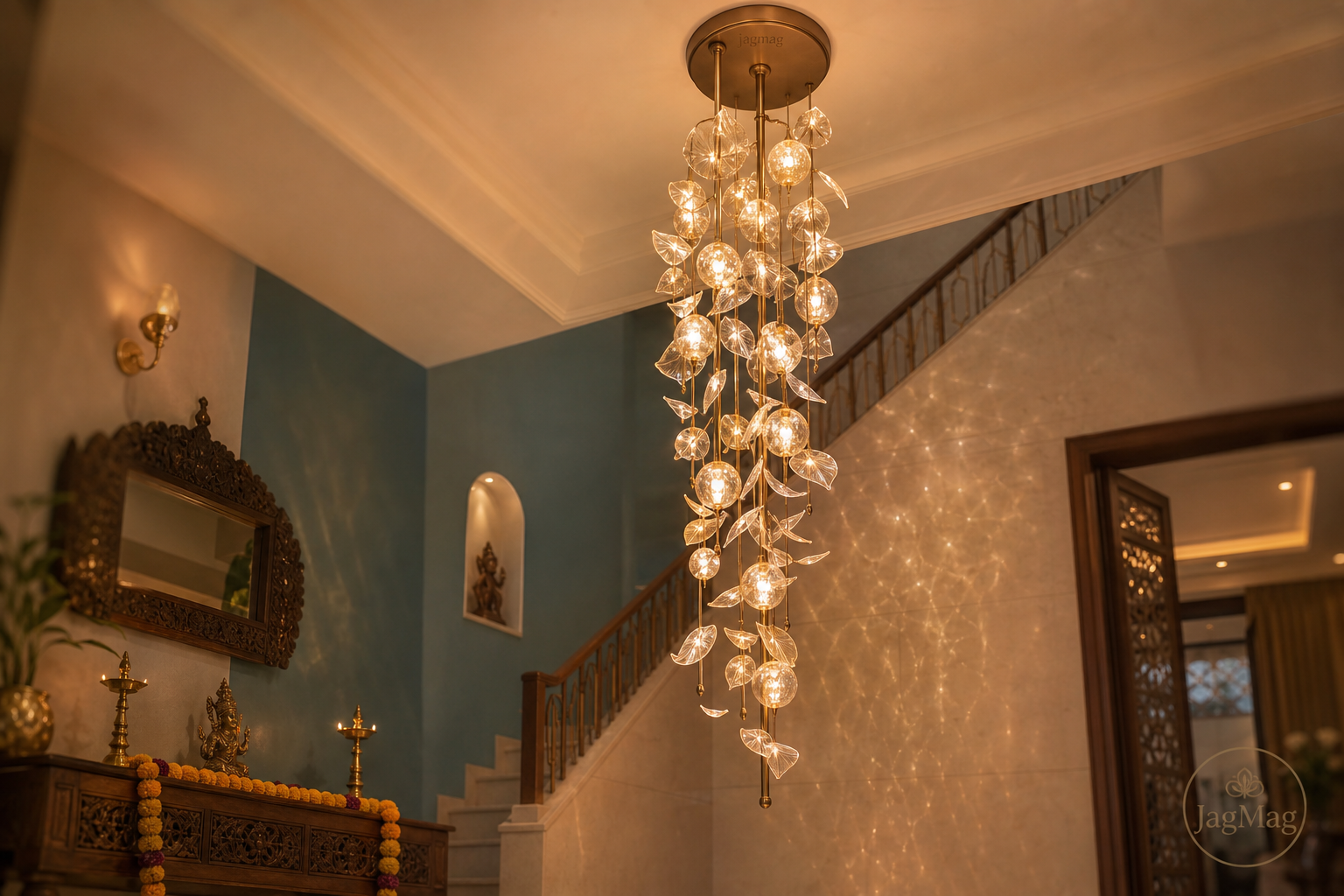 Cascading glass jhumar design glowing over a marble staircase in an Indian home