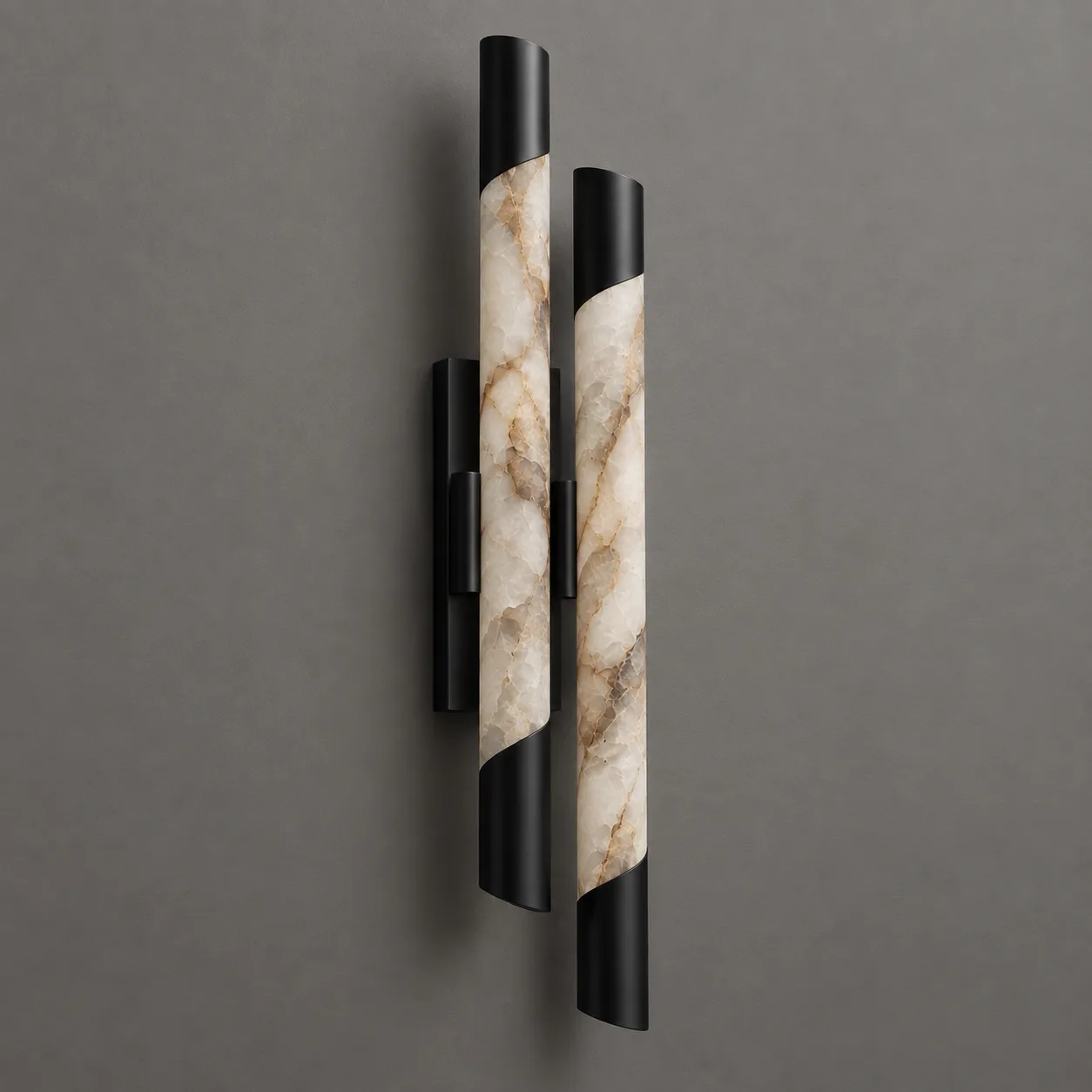 Twin alabaster tube wall sconce with a black spiral metal wrap, showing natural cream and gold stone veining, on a grey wall