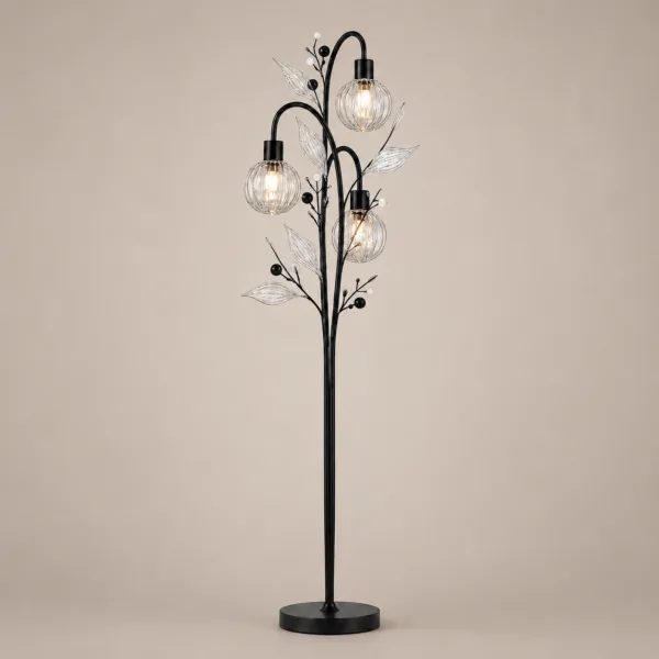 Crystal berry botanical floor lamp on warm beige background lit — three ribbed glass globe cage shades at different heights on arching black metal branches with clear borosilicate glass leaves and pearl berry accents