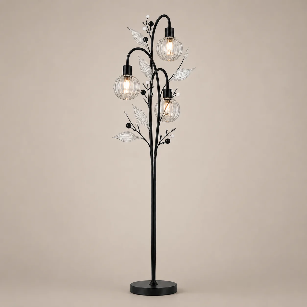 Crystal Berry Botanical Floor Lamp – 3-Light Ribbed Glass Globe Tree 4 Crystal berry botanical floor lamp on warm beige background lit — three ribbed glass globe cage shades at different heights on arching black metal branches with clear borosilicate glass leaves and pearl berry accents