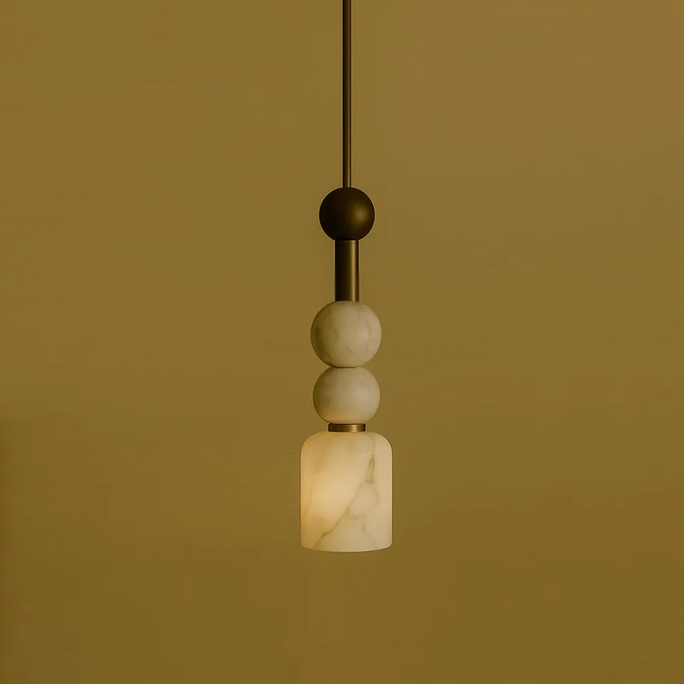 Alabaster beaded pendant light with two stone beads above a lit cylinder shade on a brass stem