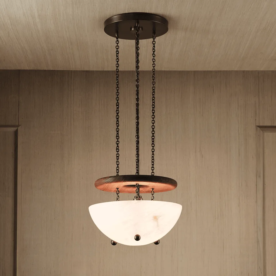 Alabaster bowl chandelier lit warm, hand-cut stone uplight bowl below a walnut ring on bronze chains