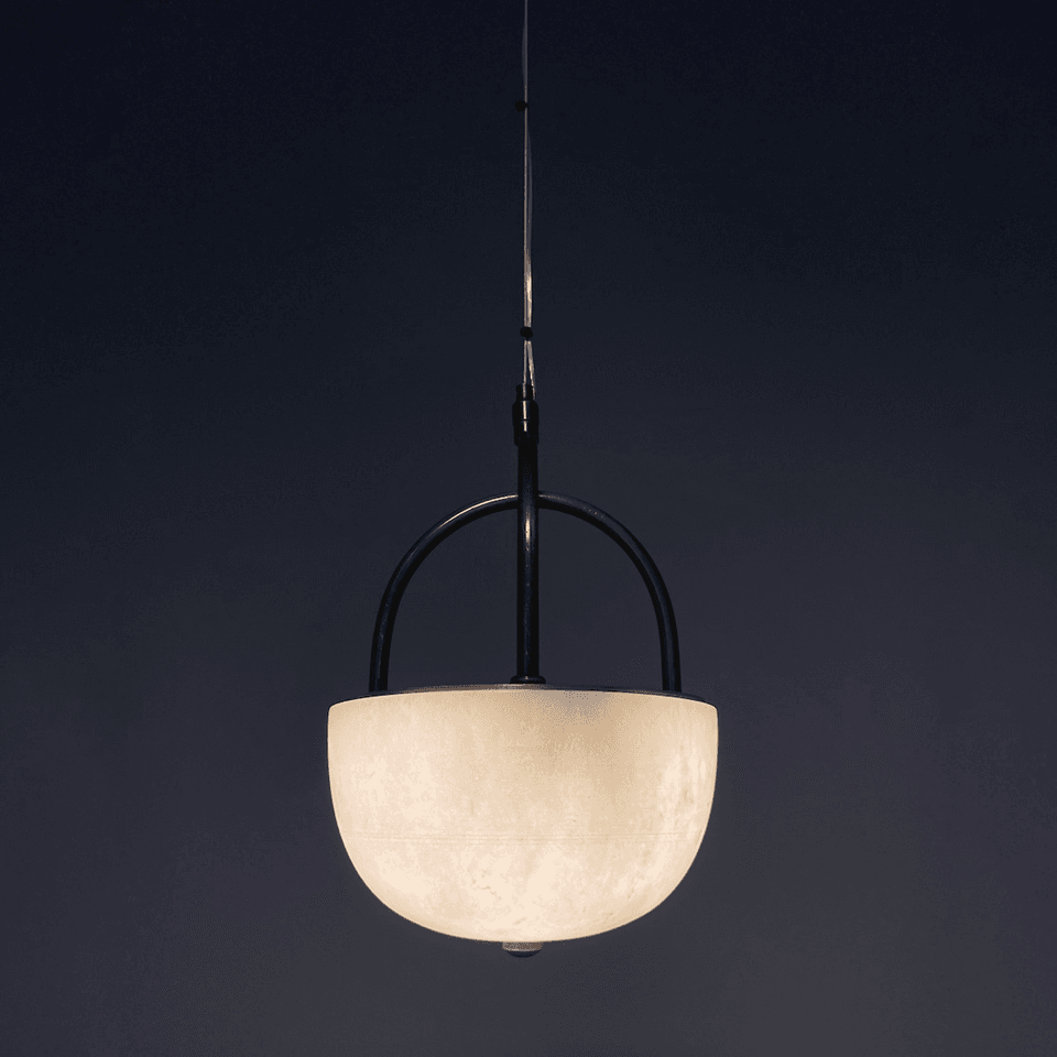 Alabaster bowl pendant light lit against a dark navy wall showing stone veining
