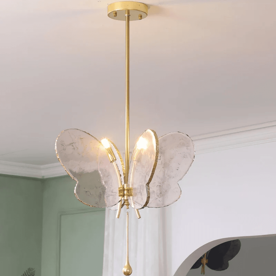 Butterfly Pendant Light – Marbled Glass Wings on Brass, 49 cm | Pink or Blue | Jagmag Lights 11 Pink butterfly pendant light lit in a room with sage green walls - Jagmag Lights