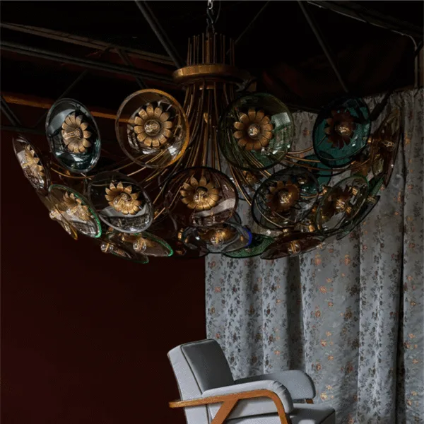 Coloured glass chandelier hung in a dark panelled room above an armchair