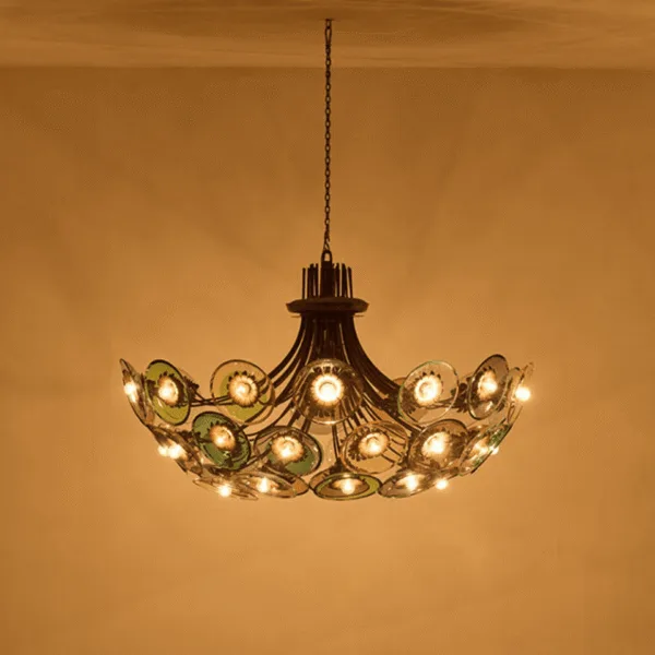Coloured glass chandelier lit against a golden wall, colour cast across the ceiling