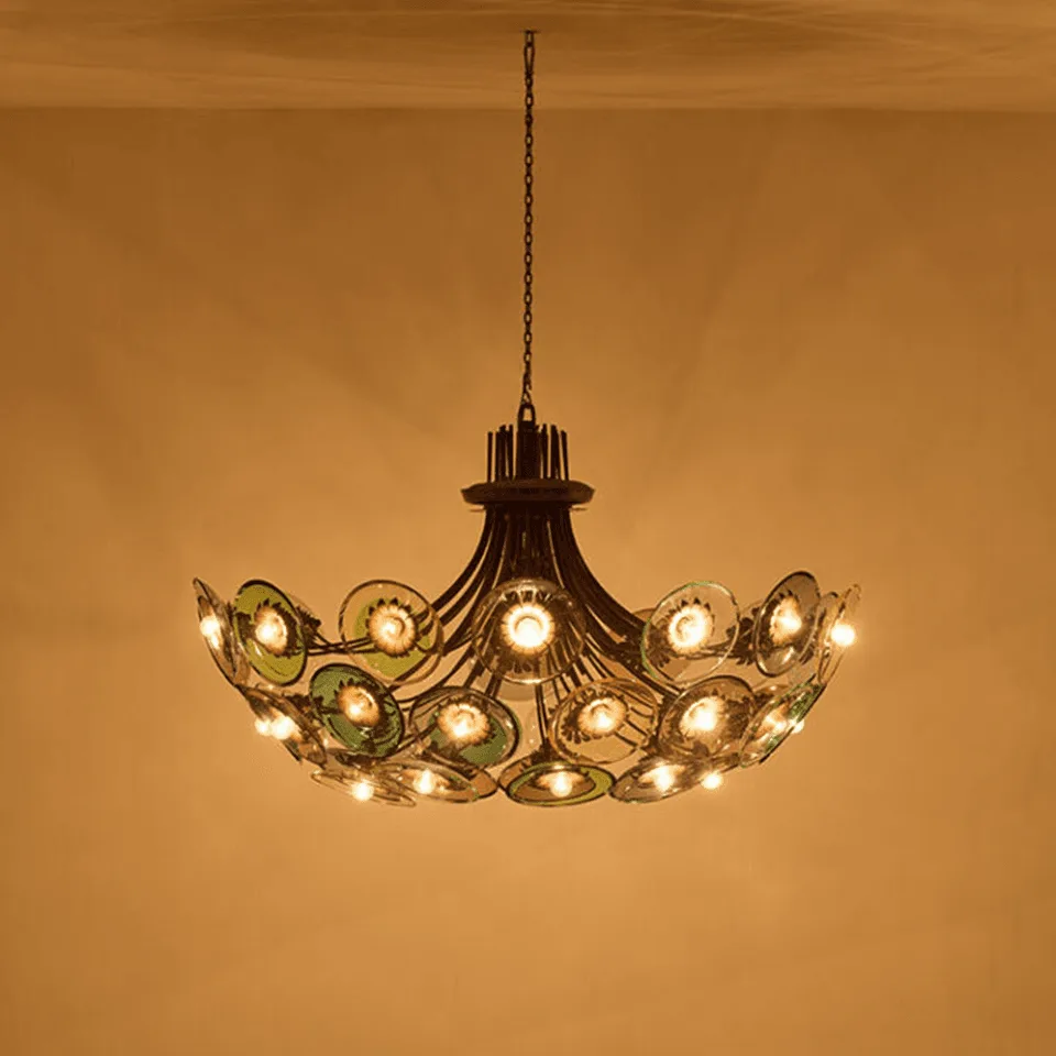 Coloured Glass Chandelier – 4 ft Brass Bowl with 6″ Glass Discs 3 Coloured glass chandelier lit against a golden wall, colour cast across the ceiling