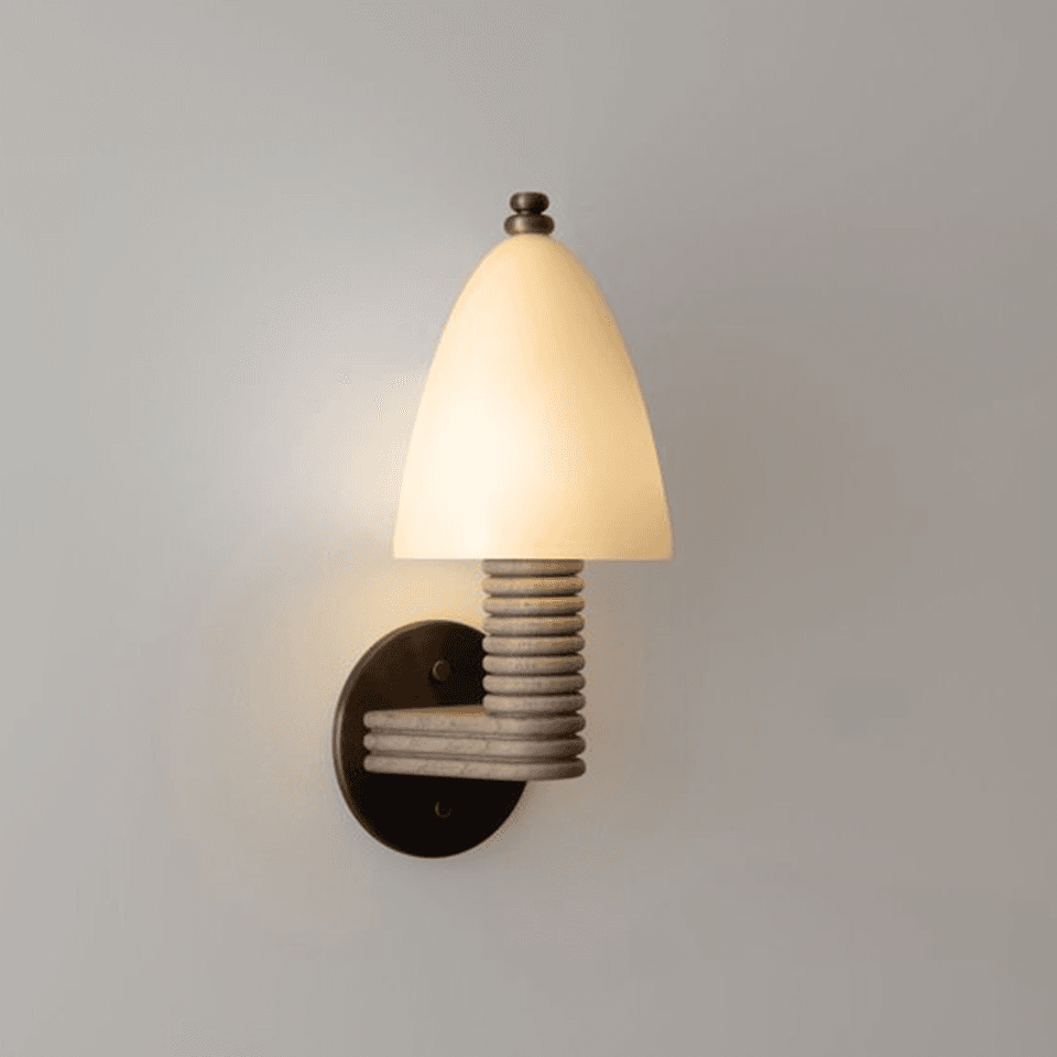 Fluted wood wall light lit warm, opal glass dome on a turned wood arm with bronze backplate