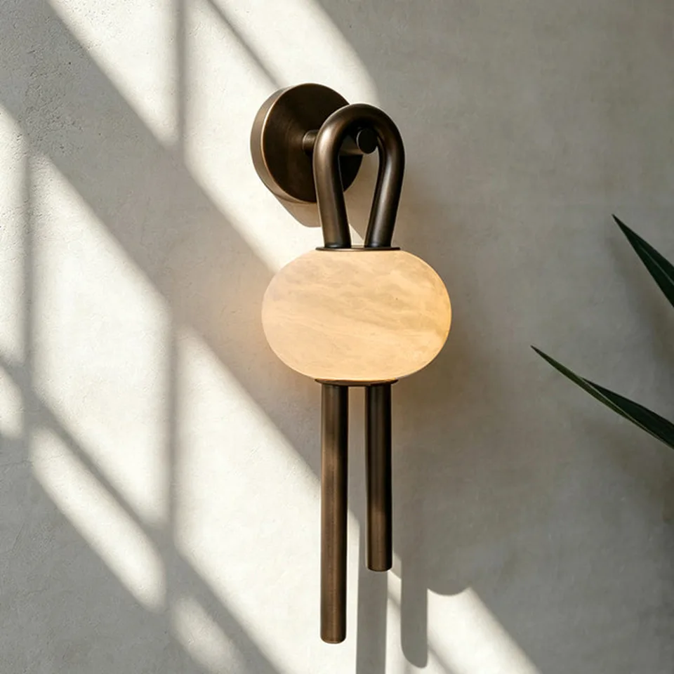 Oval Alabaster Wall Light – 53 cm Natural Stone & Bronze | Jagmag Lights 11 Oval alabaster wall light on a sunlit plaster wall showing the natural stone veining