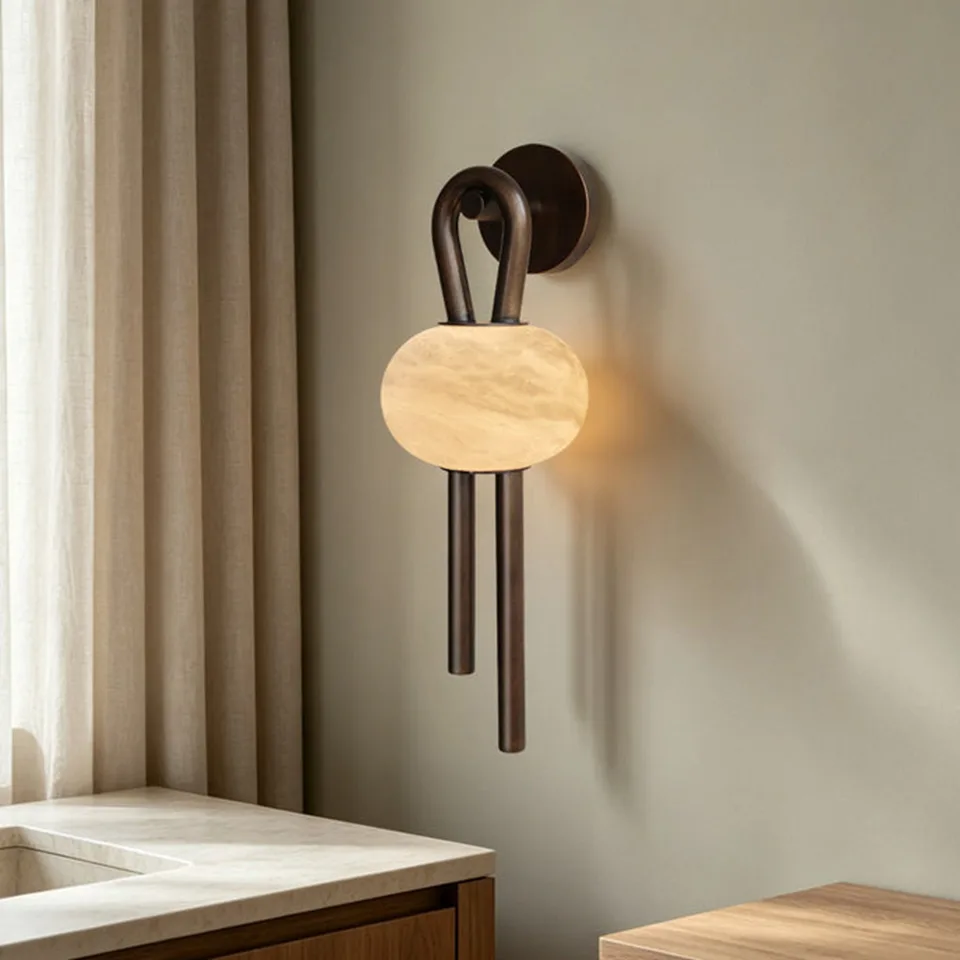 Oval Alabaster Wall Light – 53 cm Natural Stone & Bronze | Jagmag Lights 10 Side view of the oval alabaster wall light above a stone vanity, bronze rods hanging below the stone