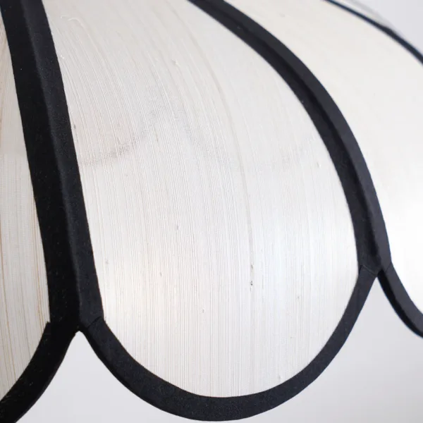 Close-up of the slub-weave ivory fabric and black bound edging on the scalloped fabric pendant light