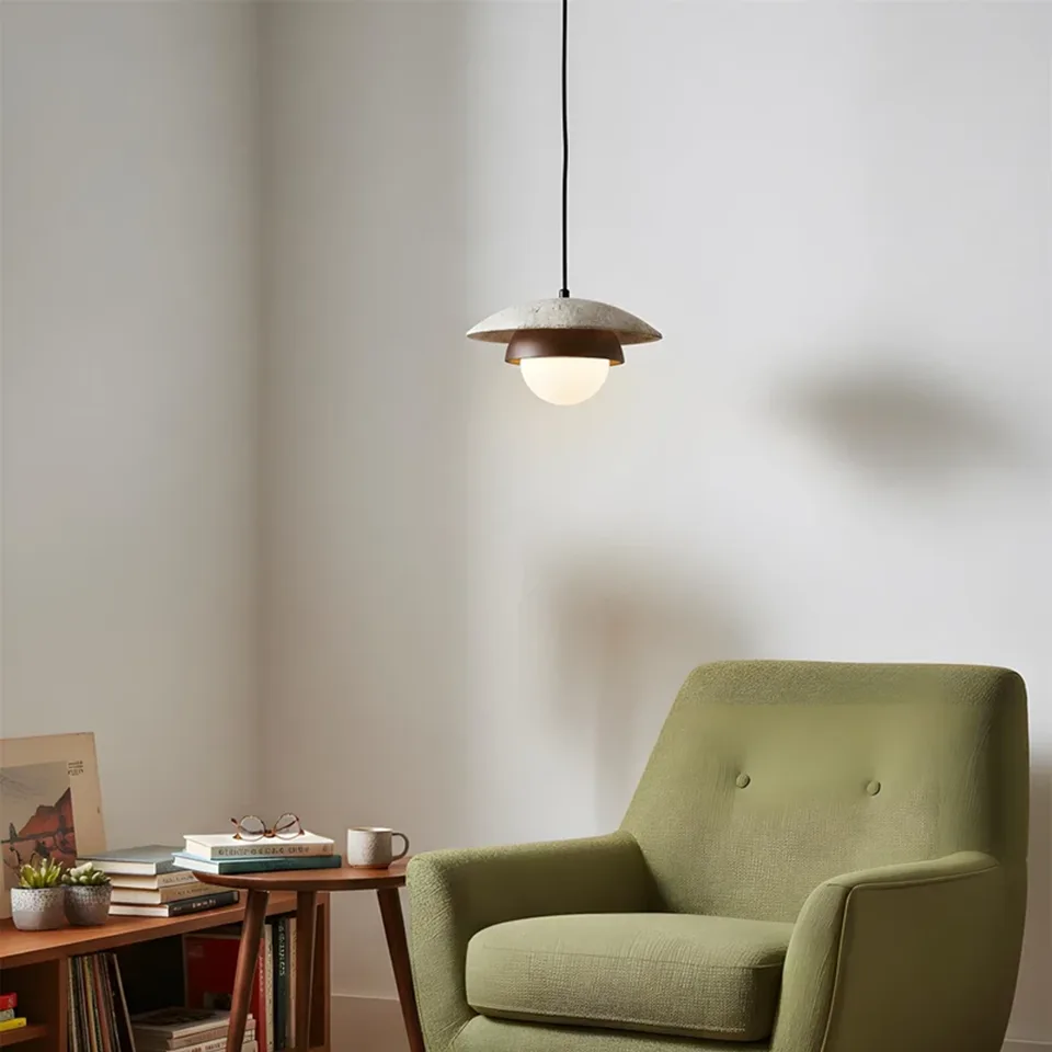 Travertine Saucer Pendant Light – Stone Disc, Rust Collar & Opal Globe, 25 cm | Jagmag Lights 8 Travertine saucer pendant light lit above an armchair and side table - Jagmag Lights