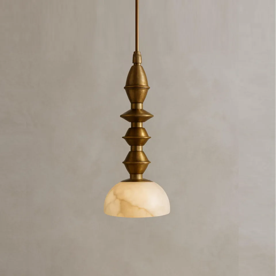 Turned brass pendant light with a four-part spindle above a cream alabaster dome