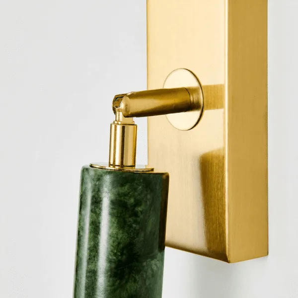 Close-up of the adjustable joint of the green wall light, 304 stainless steel in a brushed brass finish, holding the jade cylinder