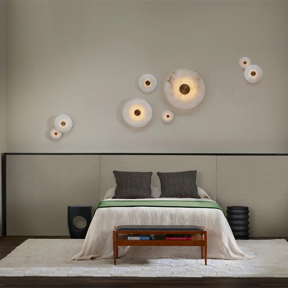 Alabaster Wall Light – Eclipse Disc Sconce, 4 Sizes | JagMag Lights 7 Alabaster Eclipse disc wall lights in mixed sizes arranged as a cluster above a bed in a modern bedroom