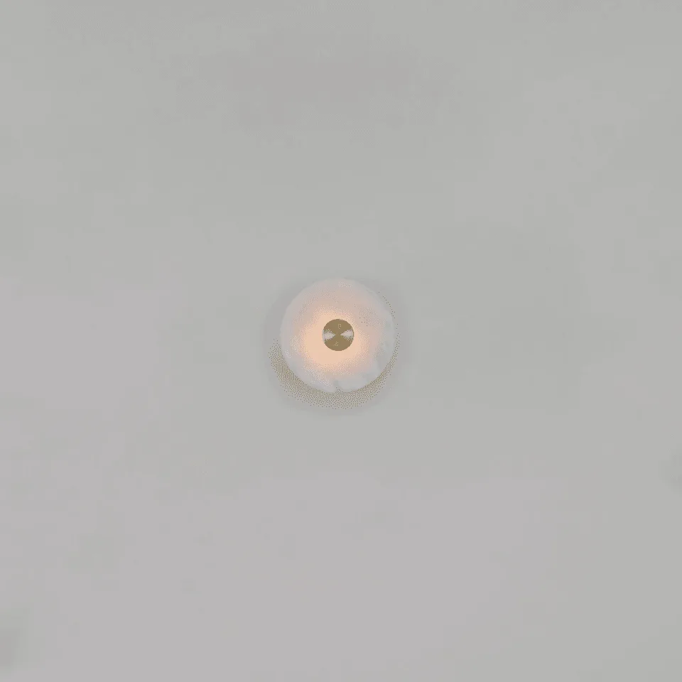 Alabaster Wall Light – Eclipse Disc Sconce, 4 Sizes | JagMag Lights 10 Smallest ø180 mm Alabaster Eclipse disc wall light lit on a large plain wall, showing its compact scale