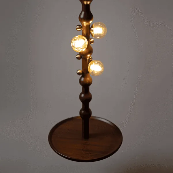 Close-up of the lit amber borosilicate glass globes and brass-finish stainless steel knobs on the teak wooden hanging lamp, teak plate below