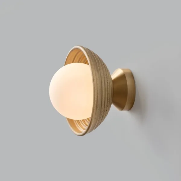 Wood wall light lit at an angle, opal borosilicate glass ball glowing within the reeded matt-gold dome
