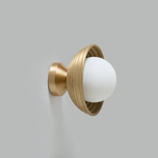 Wood wall light with a reeded matt-gold dome and lit opal borosilicate glass ball, side view on a grey wall