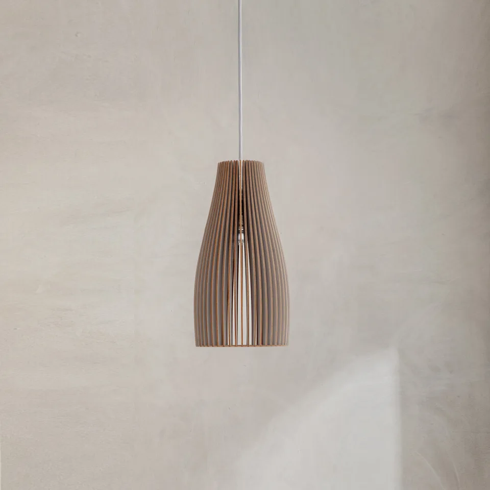 Wooden hanging light with a slatted birch plywood teardrop shade on a white cord against a plaster wall