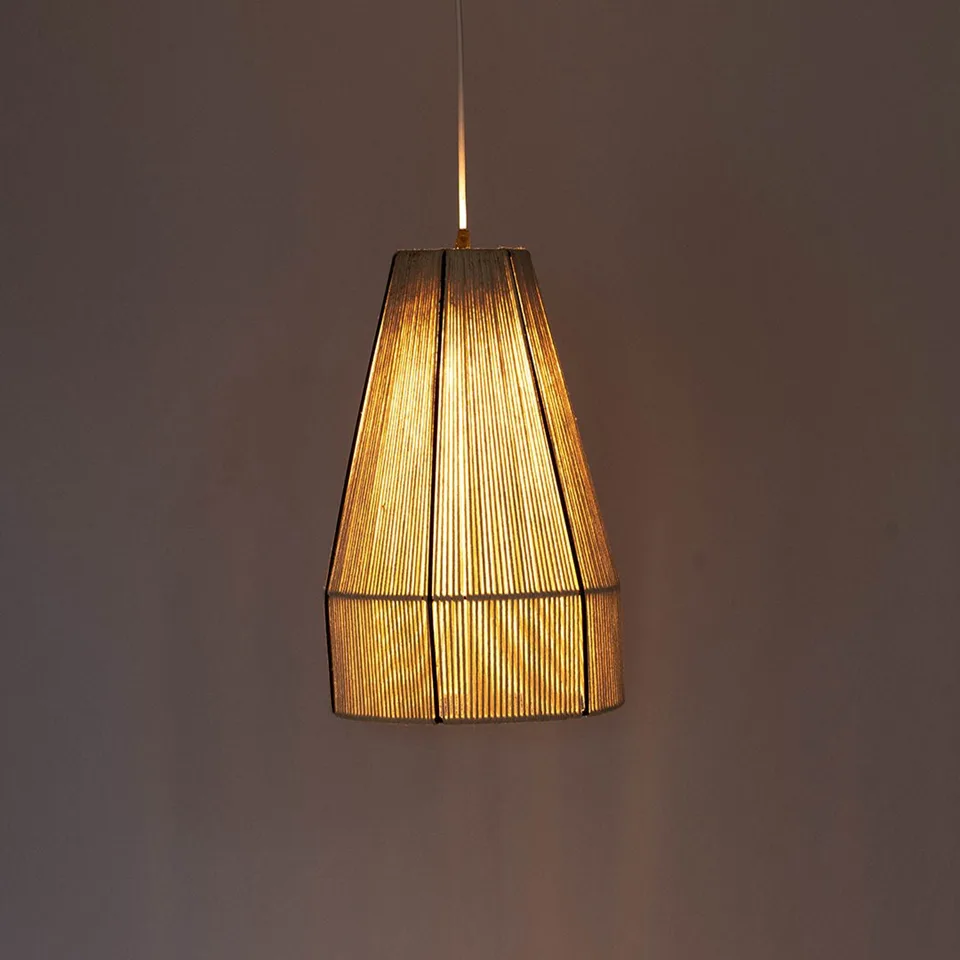 Boho pendant light in hand-wound cream raffia, lit warm against a dark wall, black ribs on the cone