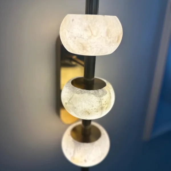 Close-up of glowing alabaster beads on the brass-finish rod