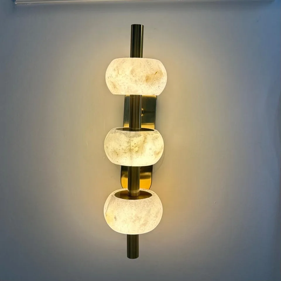 Luxury Wall Light – Three Alabaster Beads, Brass Finish, 38 cm 4 Luxury alabaster wall light glowing warm on a blue-grey wall